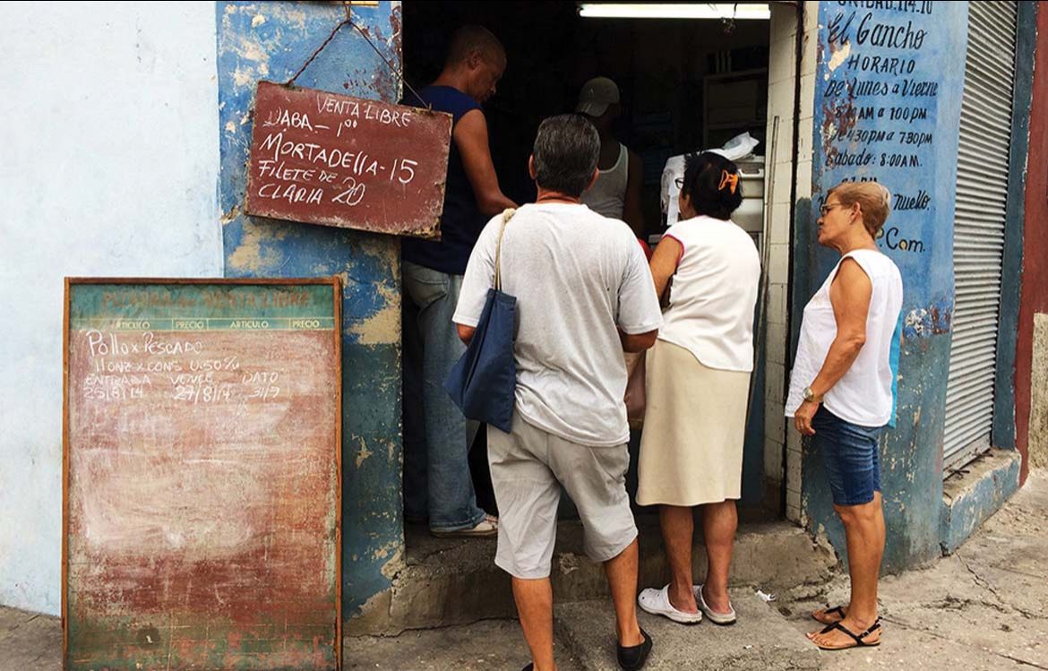 Cubains devant un magasin libreta, 2014