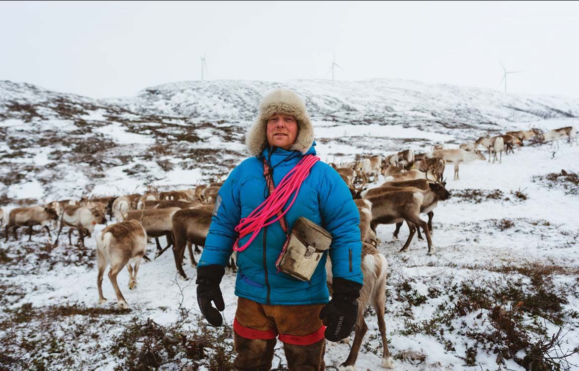 L’éleveur Reiulf Aleksandersen se tient devant ses rennes après les avoir nourris, à quelques kilomètres du parc éolien de Kvaløya.